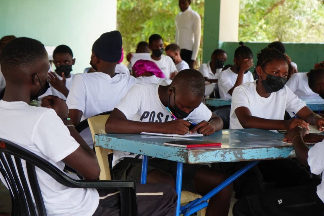 Participants writing in notebooks during a life skills lesson